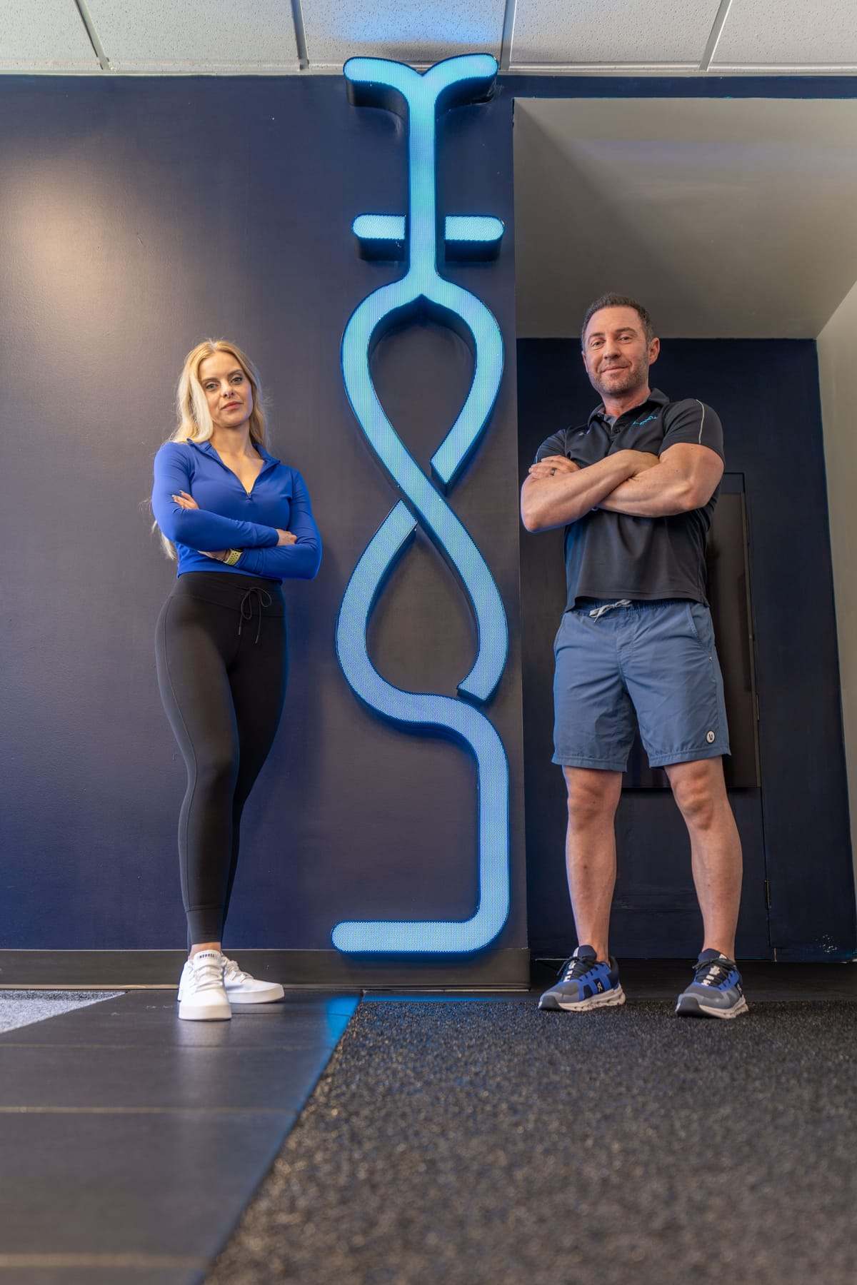 Bryan Greene and Leanne at the studio's illuminated logo wall